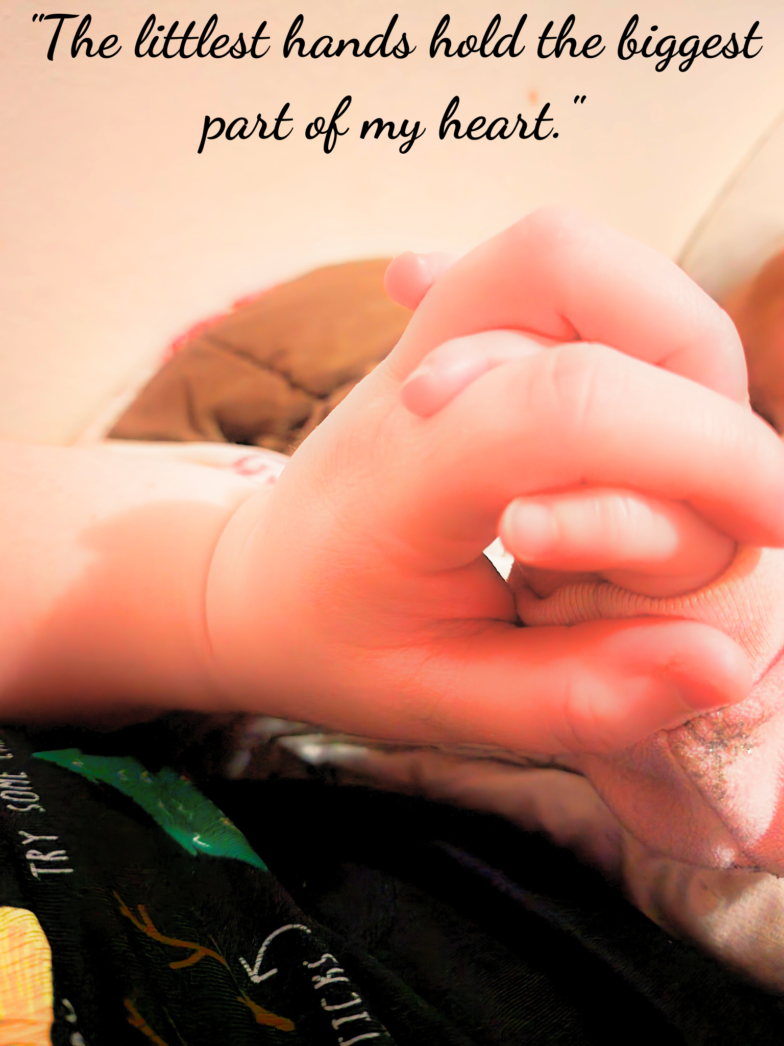 A baby’s hand wrapped around her mother’s hand